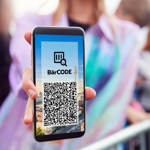 Konzertbesucherin zeigt Barcode auf ihrem Smartphone