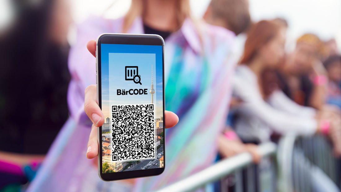 Konzertbesucherin zeigt Barcode auf ihrem Smartphone